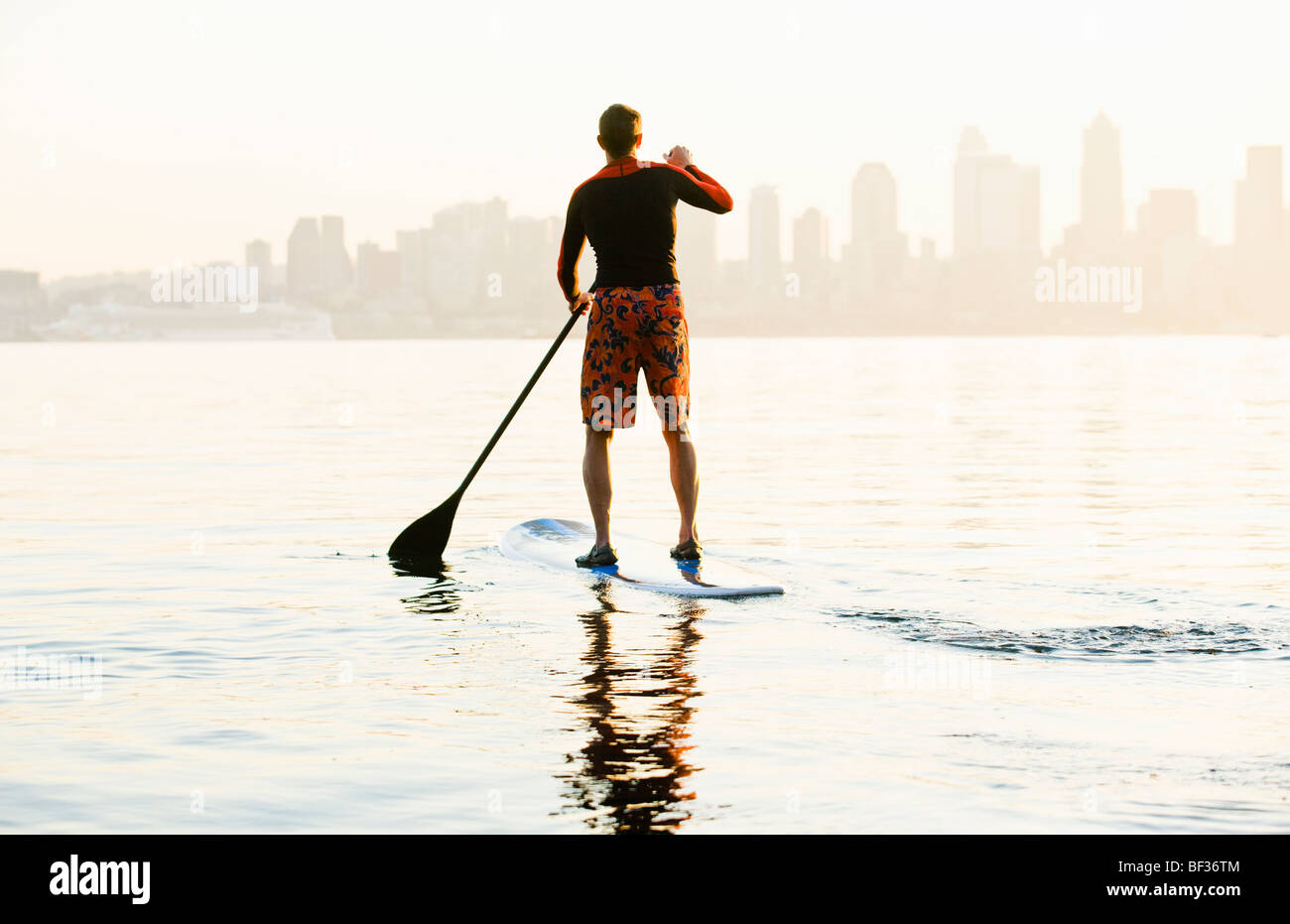 Ein Mann, Paddeln auf dem Stand up Paddle Board an der Elliott Bay mit der Seattle Space Needle im Hintergrund. Stockfoto