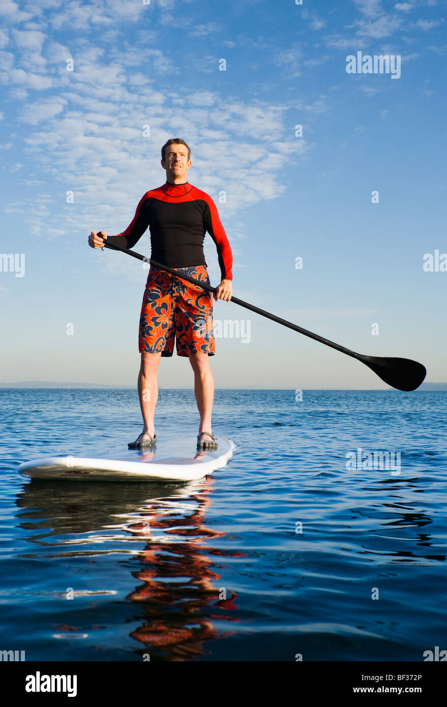 Ein Porträt eines athletischen Mannes Om ein Paddel an Bord an der Elliott Bay / Puget Sound in den frühen Morgenstunden. Stockfoto