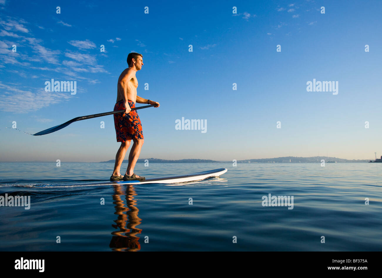 Einen späten 30er Jahren kaukasischen Mann auf ein Stand up Paddle Board auf dem Puget Sound in der Nähe von Seattle, WA. Stockfoto