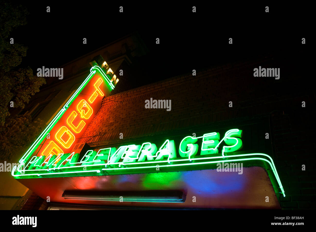 Nachtansicht der eine Leuchtreklame, die "Liquor" vertikal in rot und "Getränke" horizontal in grün sagt. Stockfoto