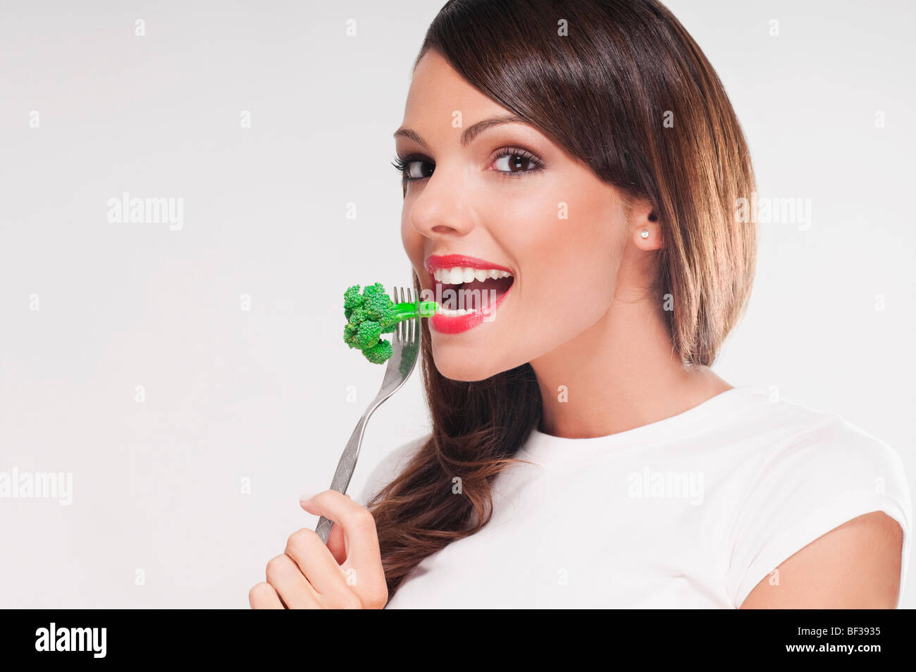 Porträt einer Frau, Brokkoli mit einer Gabel essen Stockfoto