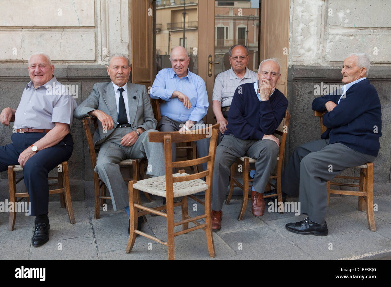 sechs alte Männer sitzen auf Stühlen außerhalb Stockfotografie - Alamy