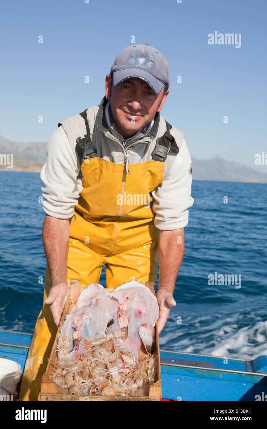 Fischer am Boot, präsentieren die Fische Stockfoto