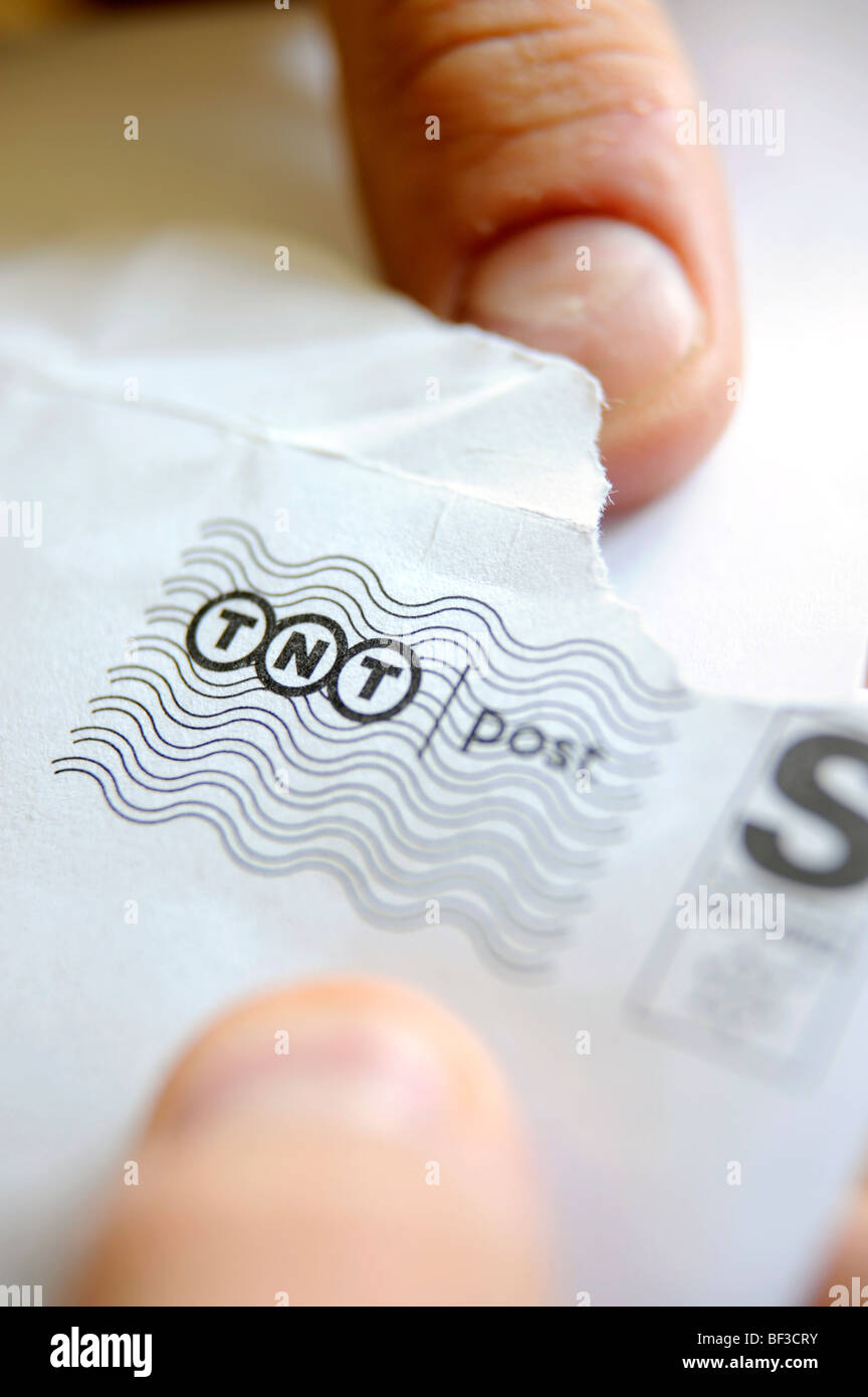 Ein Mann öffnet einen Brief von TNT geliefert Stockfoto