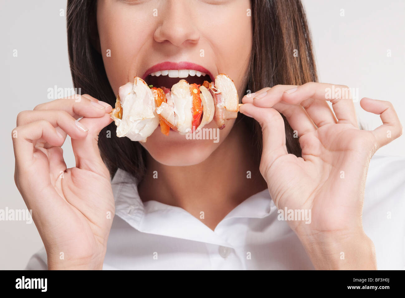 Mitte Schnittansicht einer Frau Essen Schaschlik Stockfoto