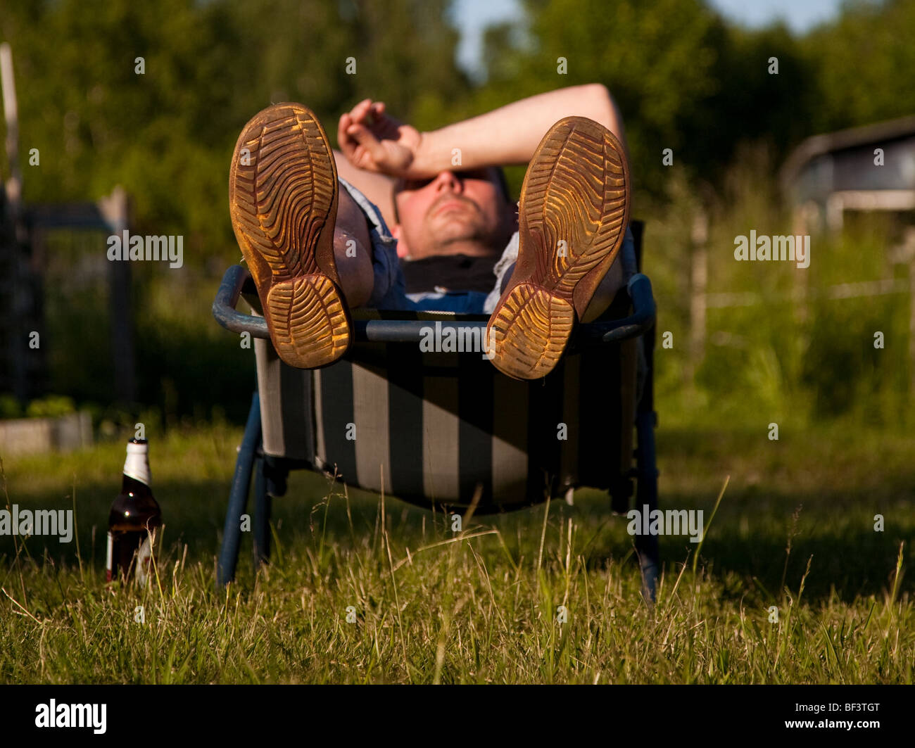 Entspannen im Liegestuhl müde Mann Stockfoto