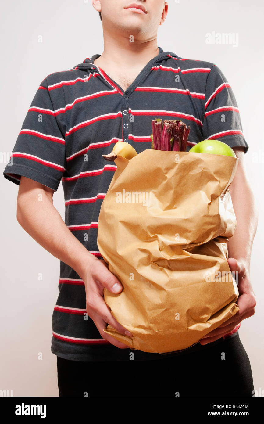 Ein Mann hält eine Tasche von Obst und Gemüse in Nahaufnahme Stockfoto