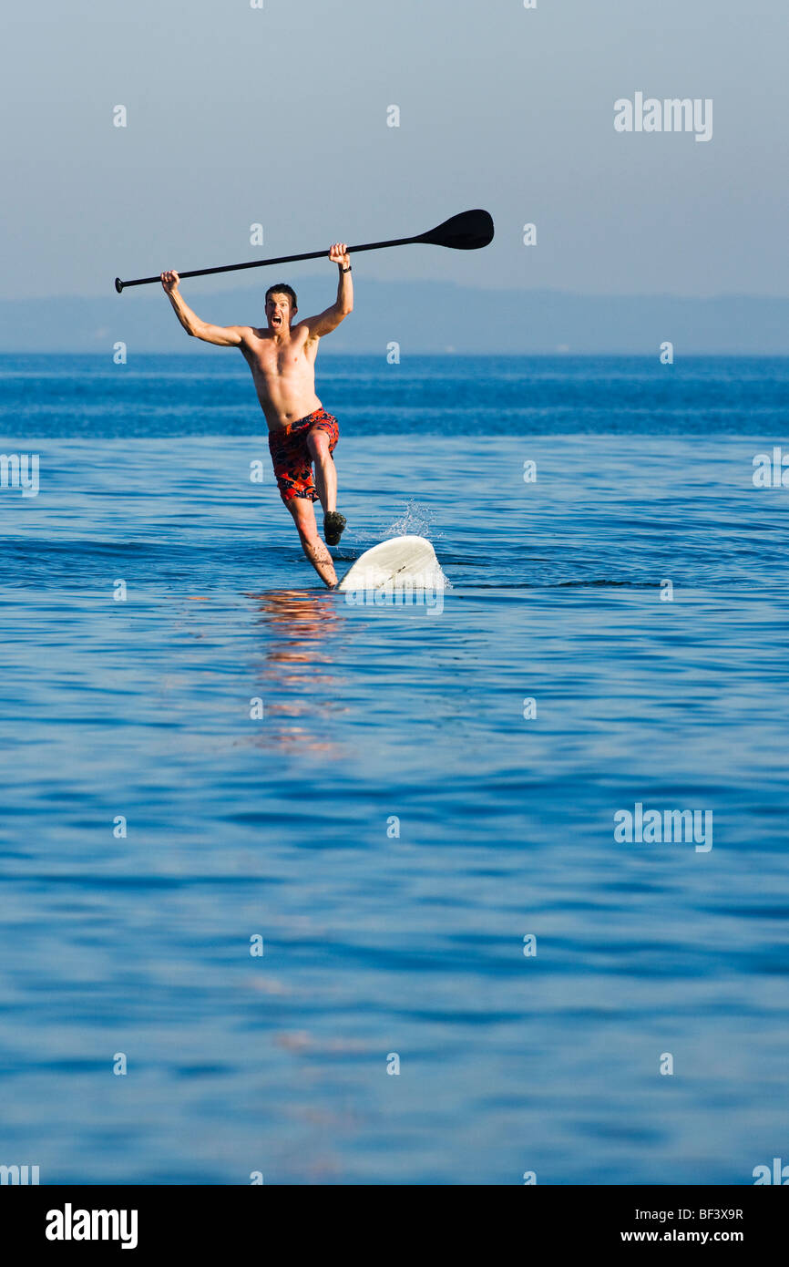 A Mitte erwachsenen Mannes Stand up Paddle Board herunterfallen. Stockfoto