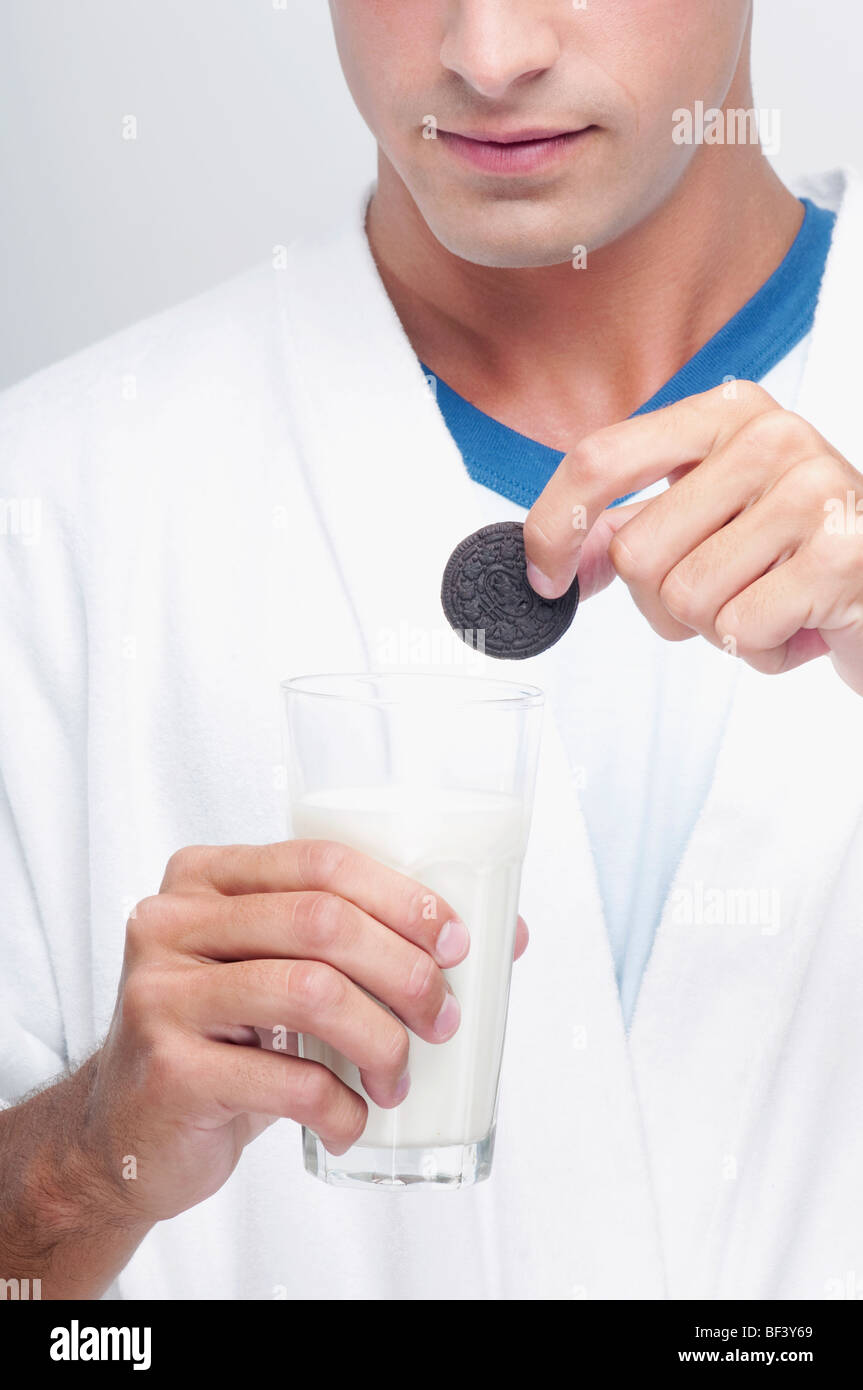 Mann einen Cookie in ein Glas Milch Eintunken Stockfoto