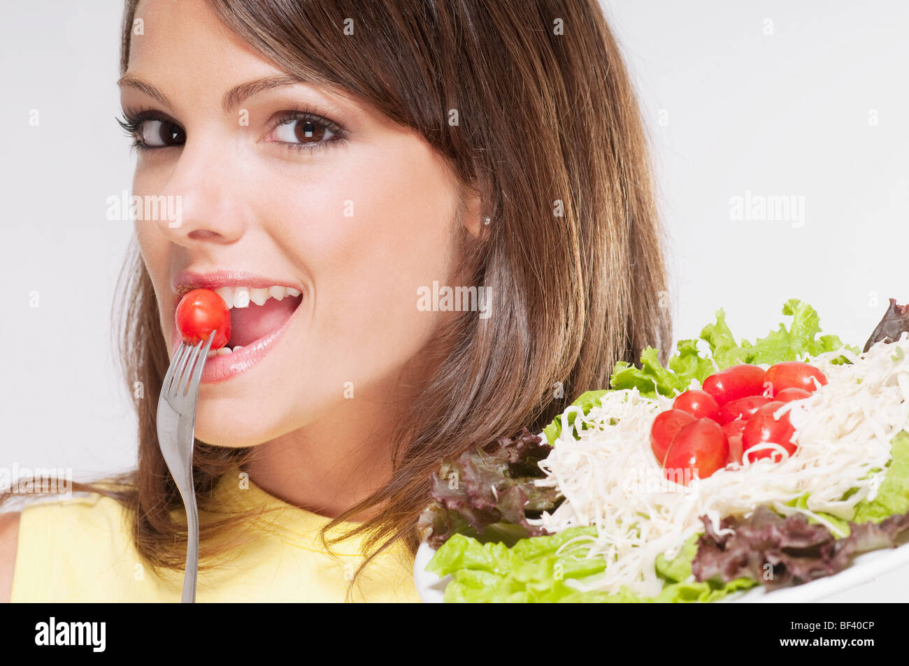 Porträt einer Frau Essen einer Kirschtomate Stockfoto