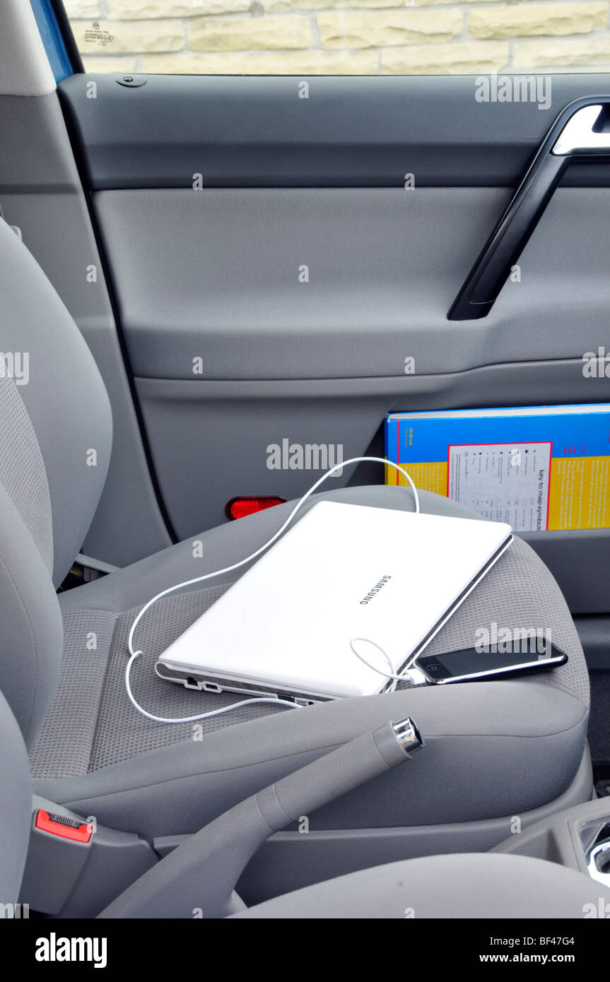 Samsung Netbook und angeschlossene Iphone links auf dem Beifahrersitz in gesperrten geparkten Auto Stockfoto