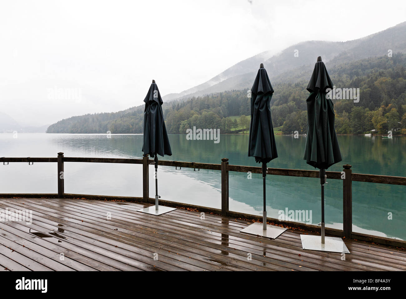 Drei geschlossene Sonnenschirme, Terrasse am See, bewölkt, Himmel, regnerischen, trüben Stimmung, See Fuschlsee, Salzkammergut Bereich, Helikopteraufnahmen Stockfoto