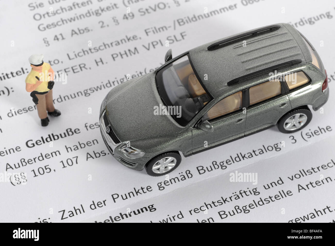 Miniatur-Polizist und VW Touareg als ein symbolisches Bild für eine Geldstrafe Stockfoto