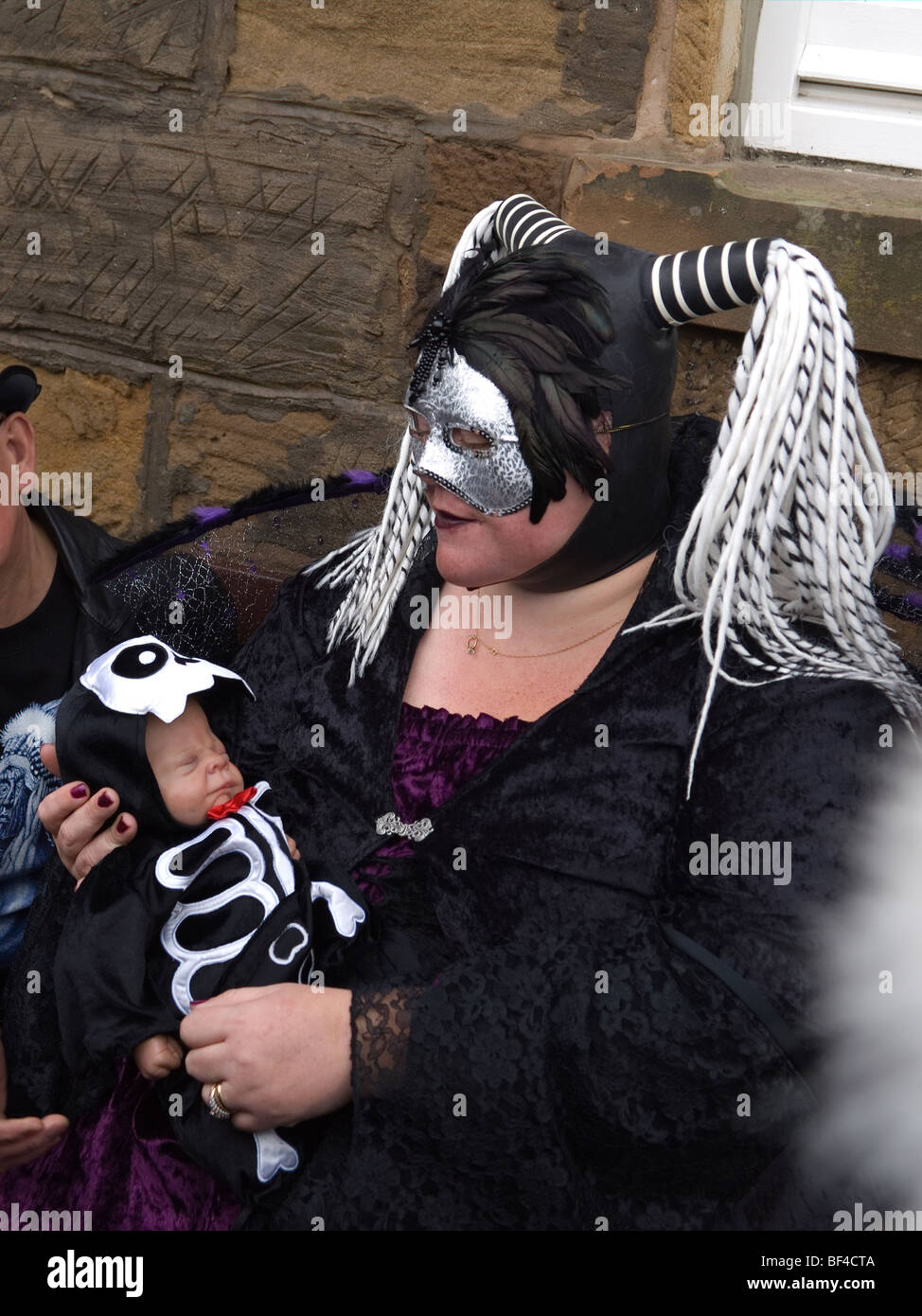 Eine Frau sitzend mit einer Babypuppe gekleidet als Goten auf der Whitby Gothic Woche Ende 2009 Stockfoto