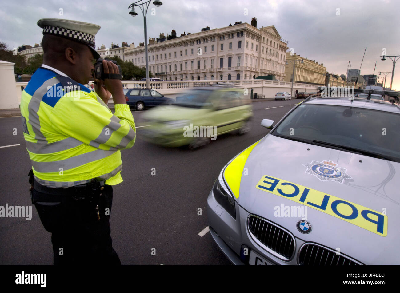 Ein schwarzer Polizist mit einem Laserkamera, Geschwindigkeitsüberschreitungen fangen Autofahrer Stockfoto