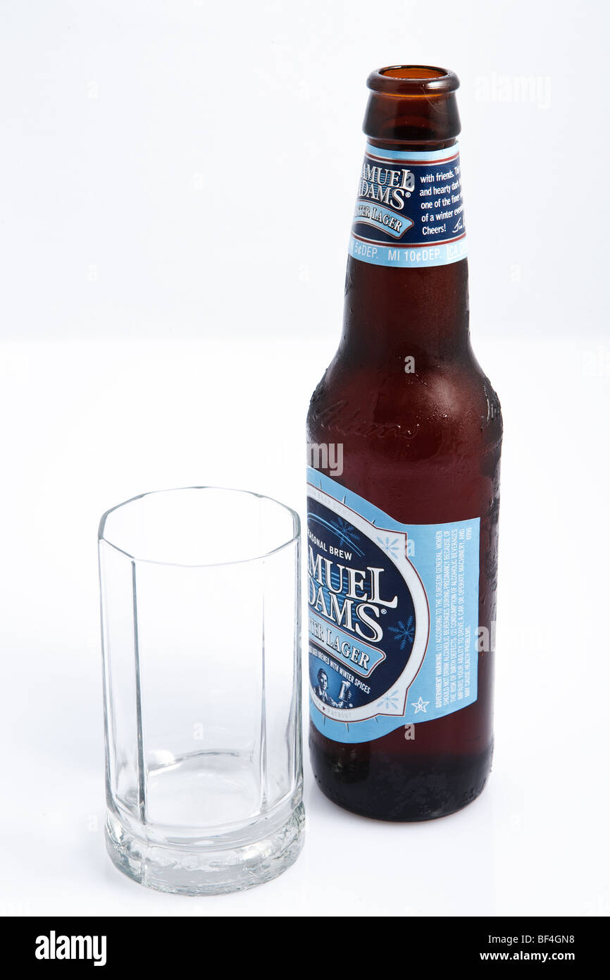 Ein kühles Bier neben einem leeren Glas Stockfoto