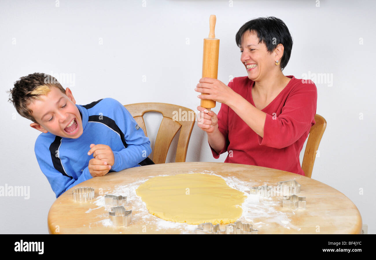 Weihnachtsbäckerei, Mutter und Sohn Scherze, sind Teig und Cookie Cutter auf dem Tisch liegen. Stockfoto