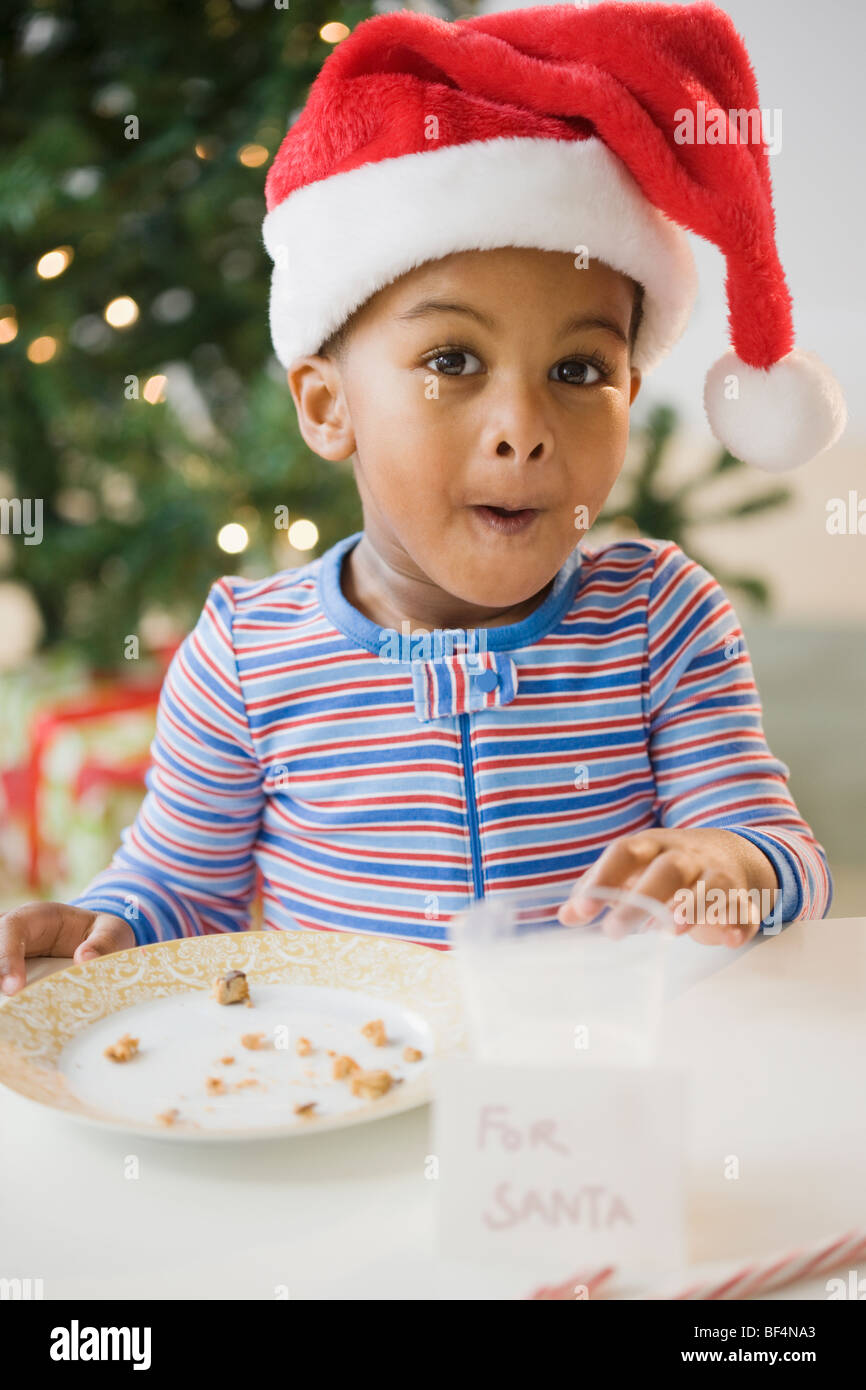 African American Boy auf Cookies von "Für Santa" Zeichen gegessen Stockfoto