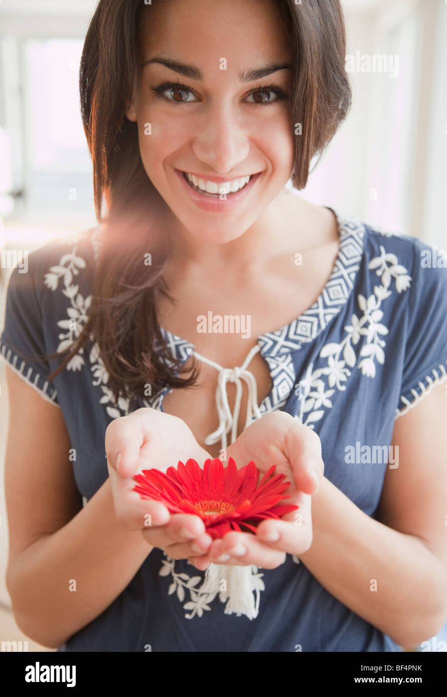 Hispanic Woman Holding Blume Stockfoto