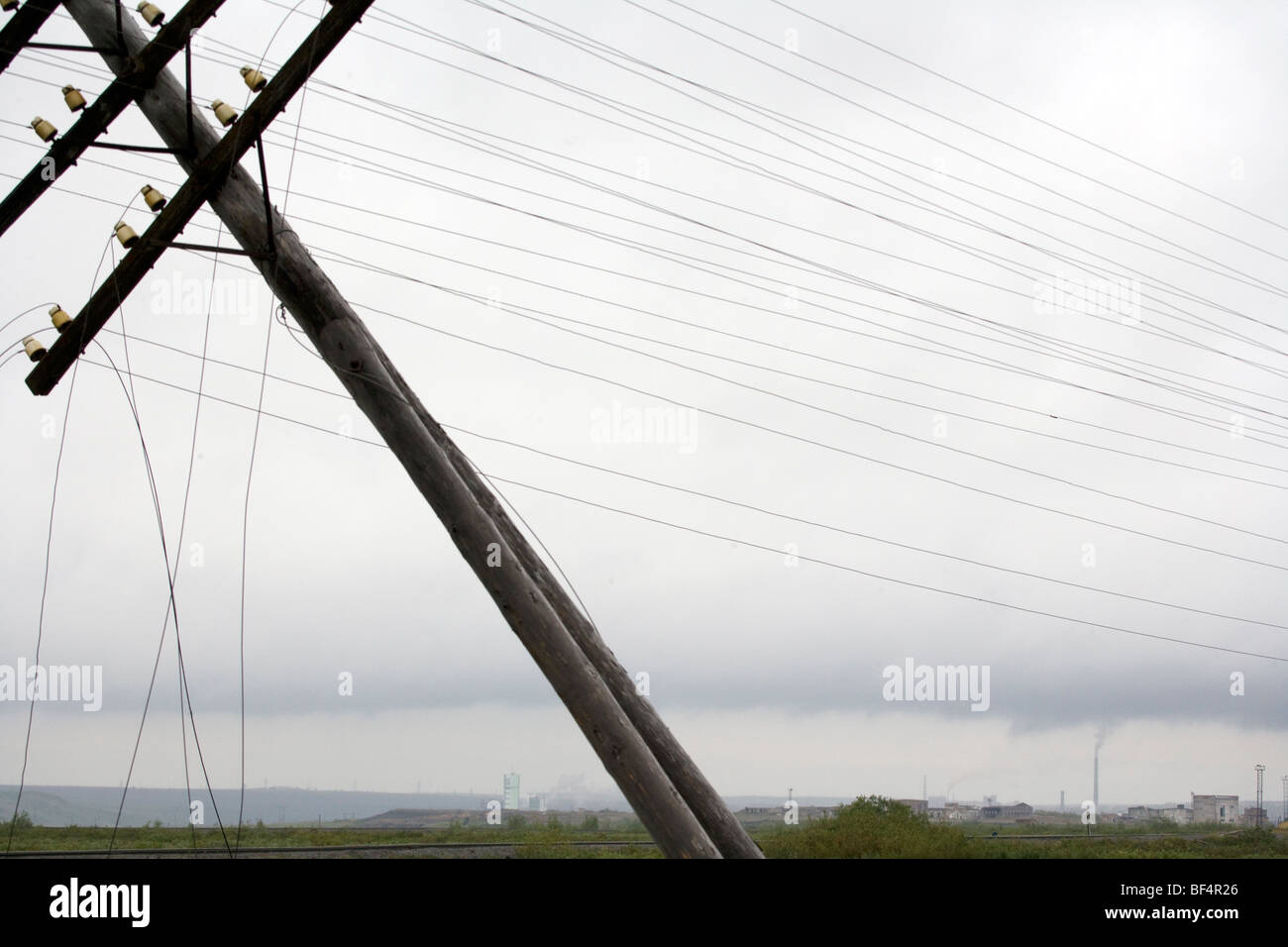 Gefallenen Telegraphenmast mit industriellen Gebäuden und Schornsteine am fernen Horizont, Ural, arktischen Russland Stockfoto