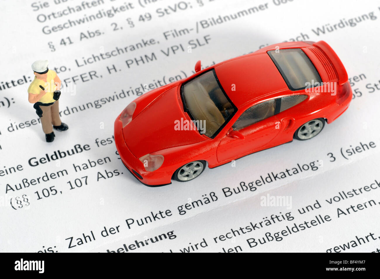 Miniatur-Polizist und Porsche als ein symbolisches Bild für eine Geldstrafe Stockfoto