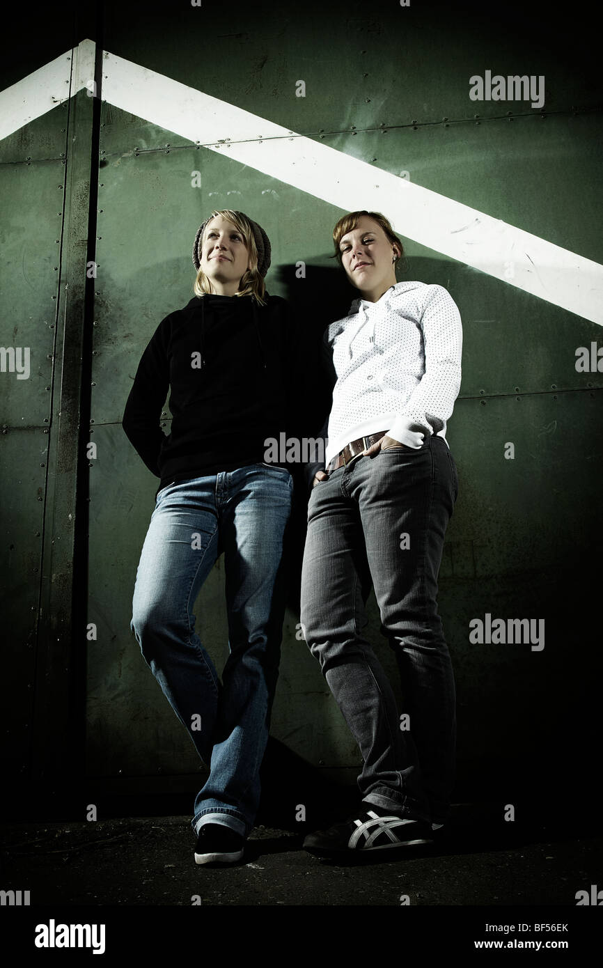 Porträt zweier junger Frauen, lehnte sich gegen einen alten Stahltür, Jugend, cool Stockfoto