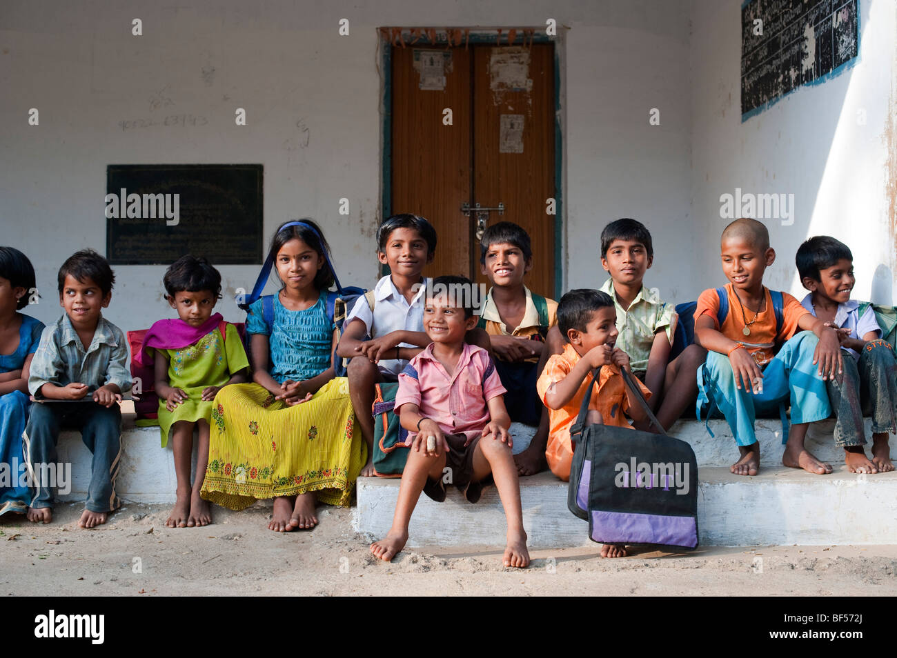 Indian School Kinder außerhalb ihrer ländlichen Dorfschule sitzen. Andhra Pradesh, Indien Stockfoto
