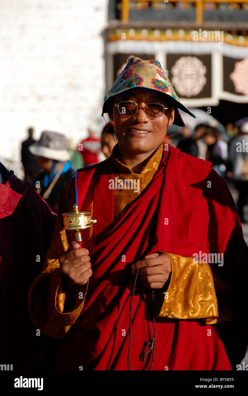 Tibetischen Buddhismus, Kora Pilger, freundliche Mönch gekleidet in roten Roben mit einer Kappe und eine Gebetsmühle unterwegs, um die Barkhor, Jo Stockfoto