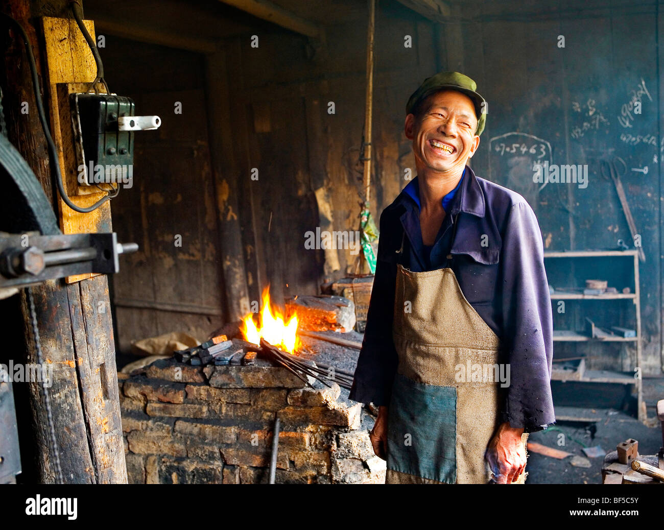 Schmied in seinem Atelier, Lächeln, Weifang, Provinz Shandong, China Stockfoto