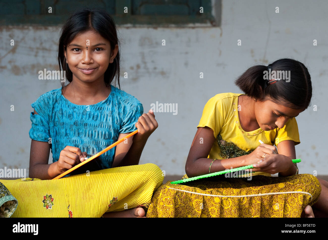 Indian School Mädchen sitzen außerhalb ihrer Schule schreiben auf der Schiefertafel, Andhra Pradesh, Indien Stockfoto