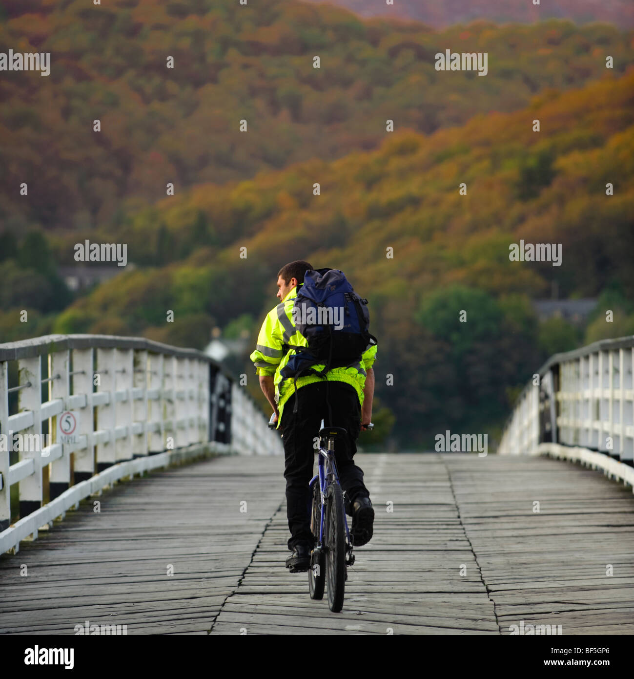 Ein Radfahrer, die Überquerung der alten hölzernen Privatbesitz Maut Brücke beim Penmaenpool, Mawddach Flussmündung, Snowdonia-Nationalpark UK Stockfoto