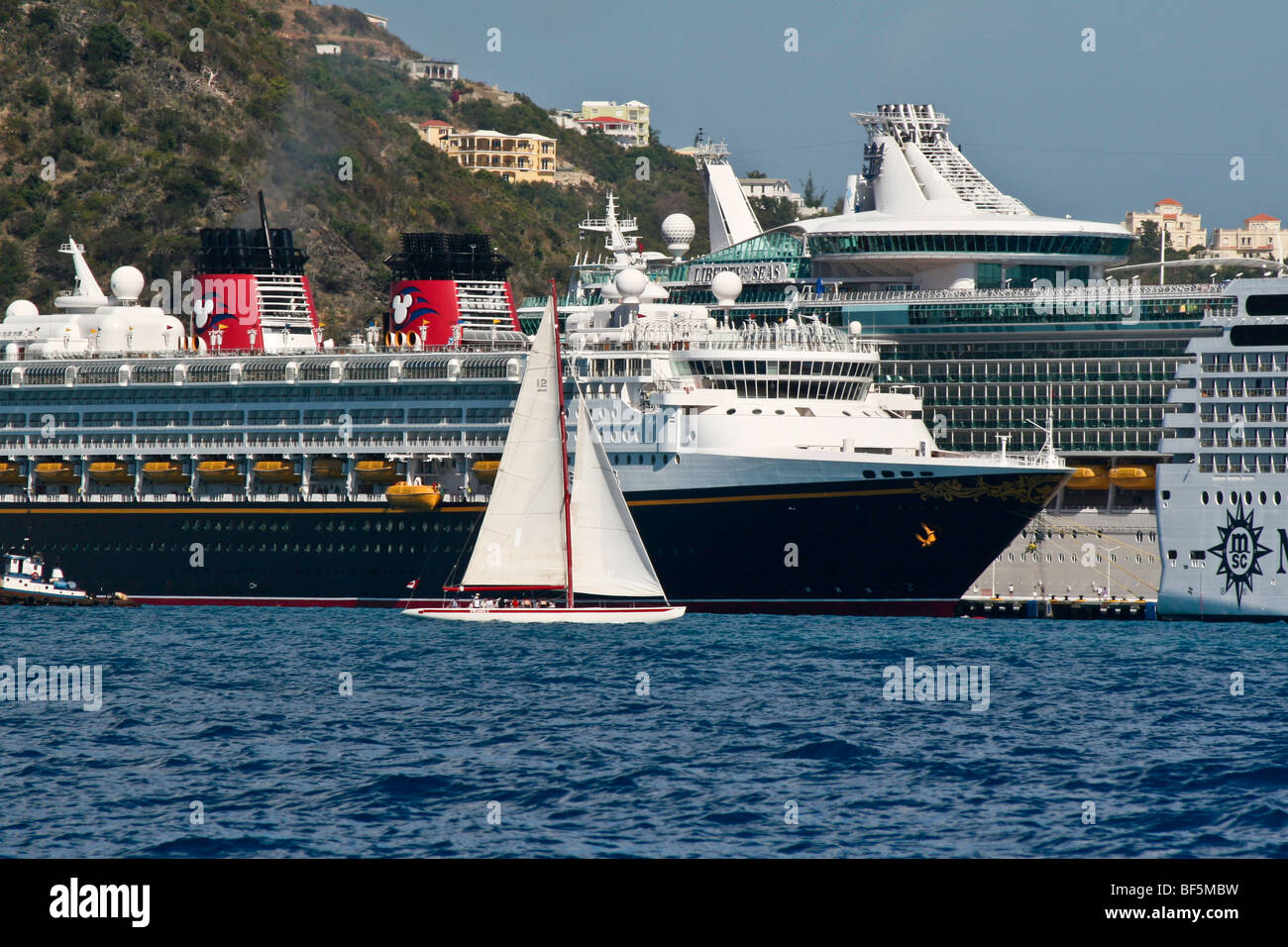 Die zwölf Meter Yacht Kanada fährt vorbei an Kreuzfahrtschiffe in Great Bay, Philipsburg, Sint Maarten Stockfoto