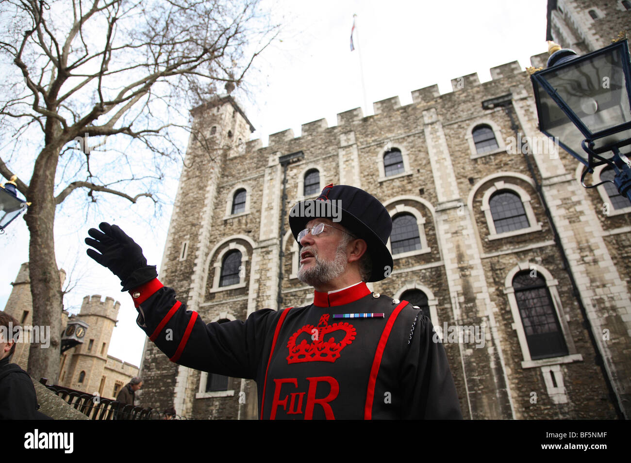 Ein Beefeater erzählt die Geschichten von den Tower of London für Touristen. Stockfoto