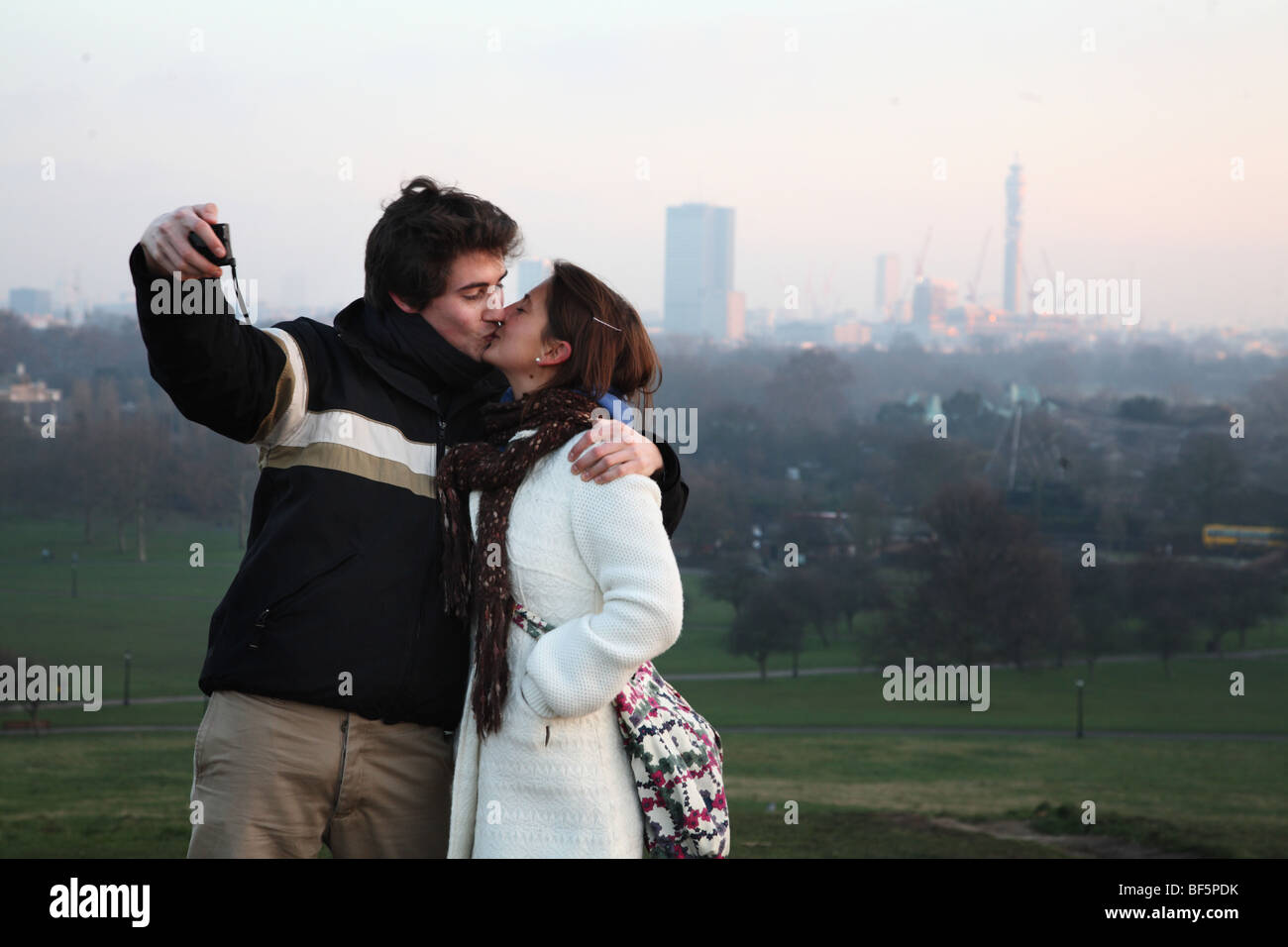 Liebhaber in Primrose Hill küssen und dabei ihr eigenes Bild mit dem Blick auf London. Stockfoto