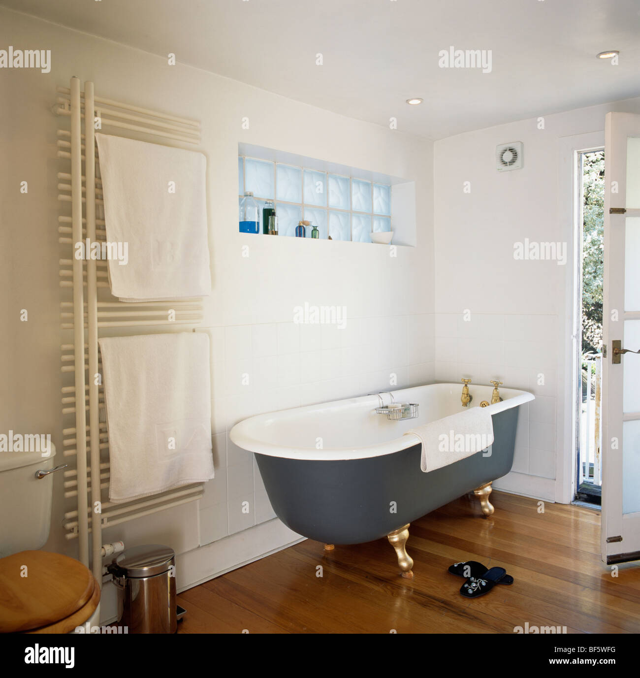 Schwarzen Roll Top Badewanne Und Holzboden In Modernes Weisses Bad Mit Weissen Handtuchern Auf Vertikale Wand Heizkorper Stockfotografie Alamy