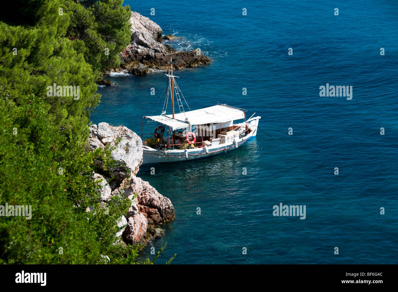 Ein traditioneller griechischer Boot oder Boot segelt gefesselt auf der felsigen Küste auf der griechischen Insel Skopelos festgemacht, die Sporaden, griechische Inseln, Griechenland Stockfoto