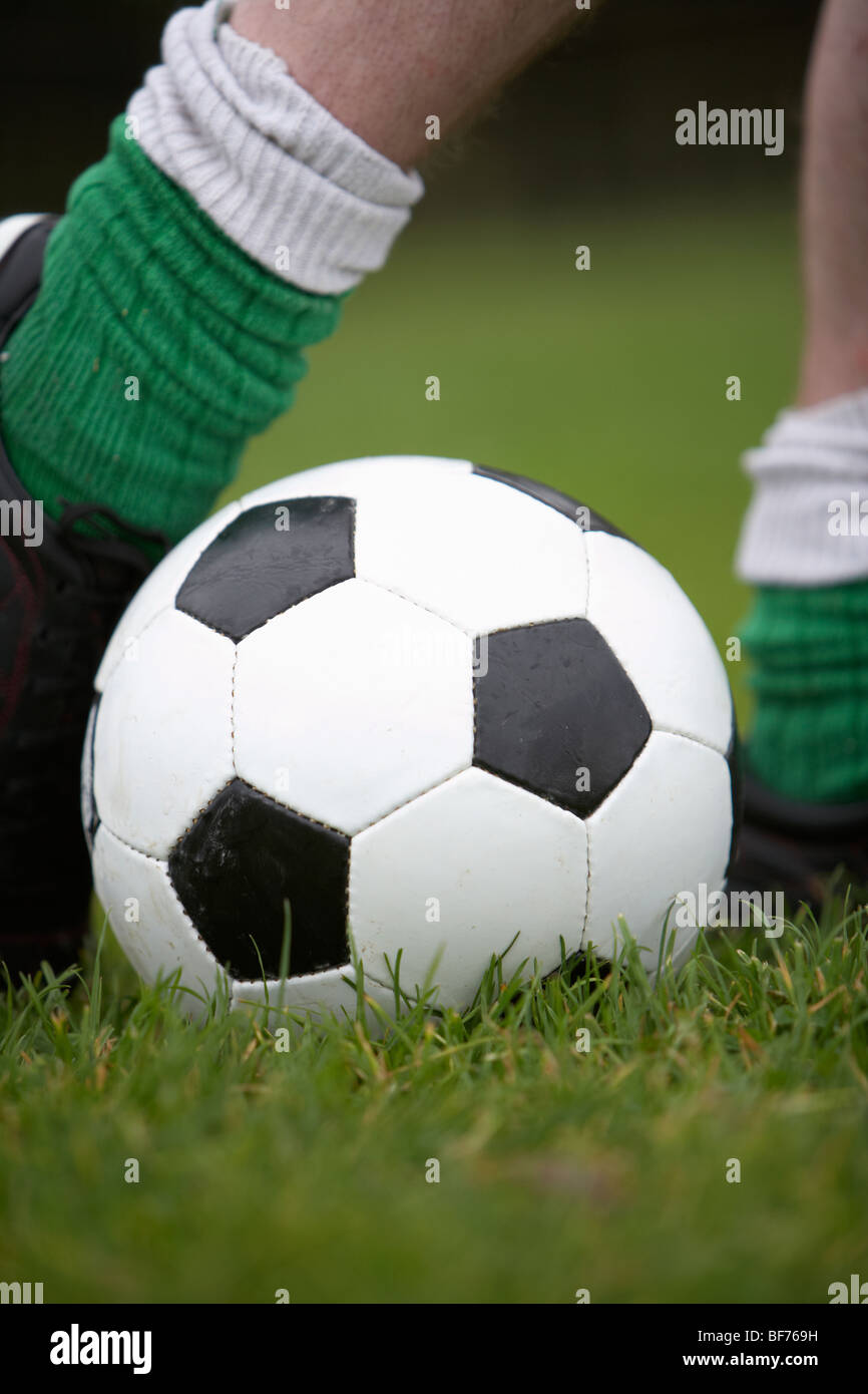 Fußball-Football-Spieler voran, einen Ball zu treten Stockfoto