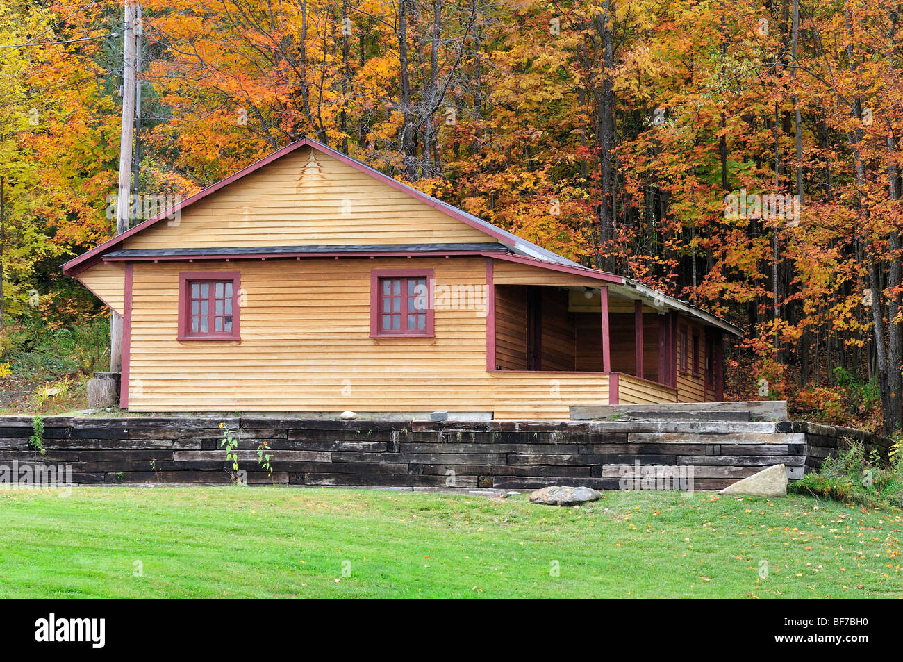 Ein rustikales Holzhaus sitzt unter Herbstlaub in Vermont, USA. Stockfoto