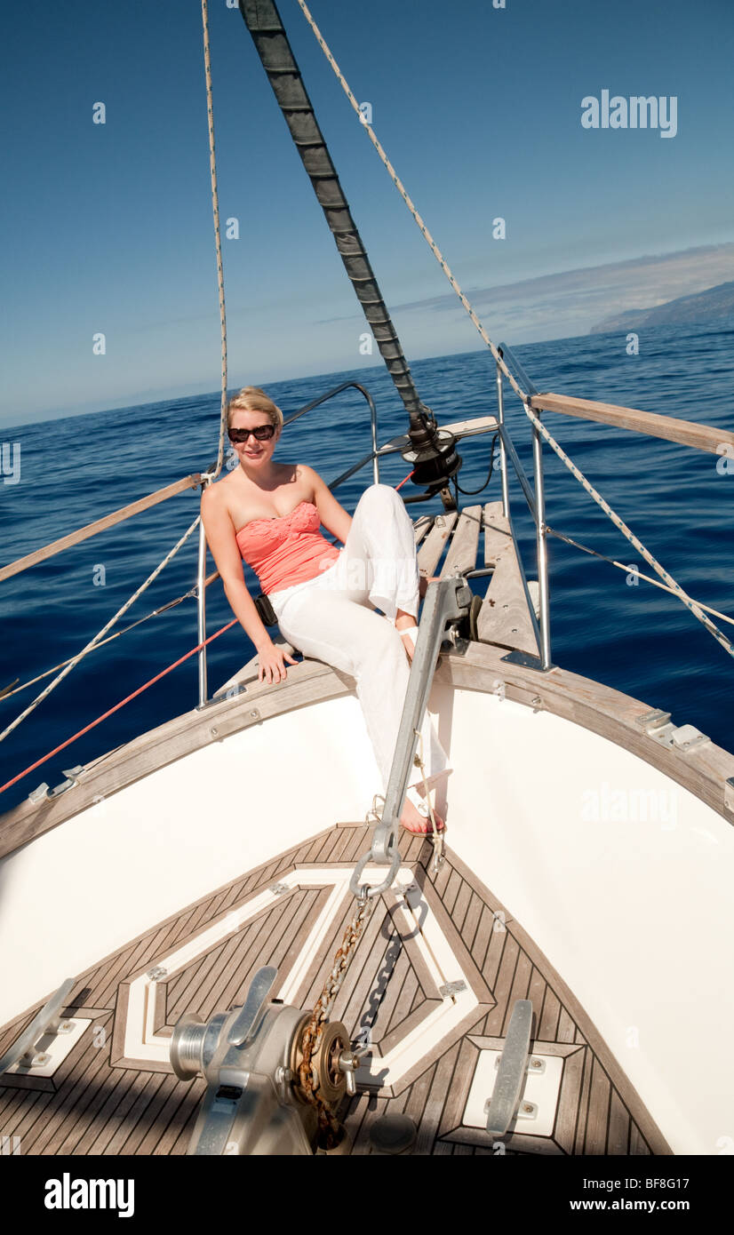 Eine attraktive, junge, blonde Frau entspannt sich in den Bogen einer Segelyacht, Madeira Stockfoto