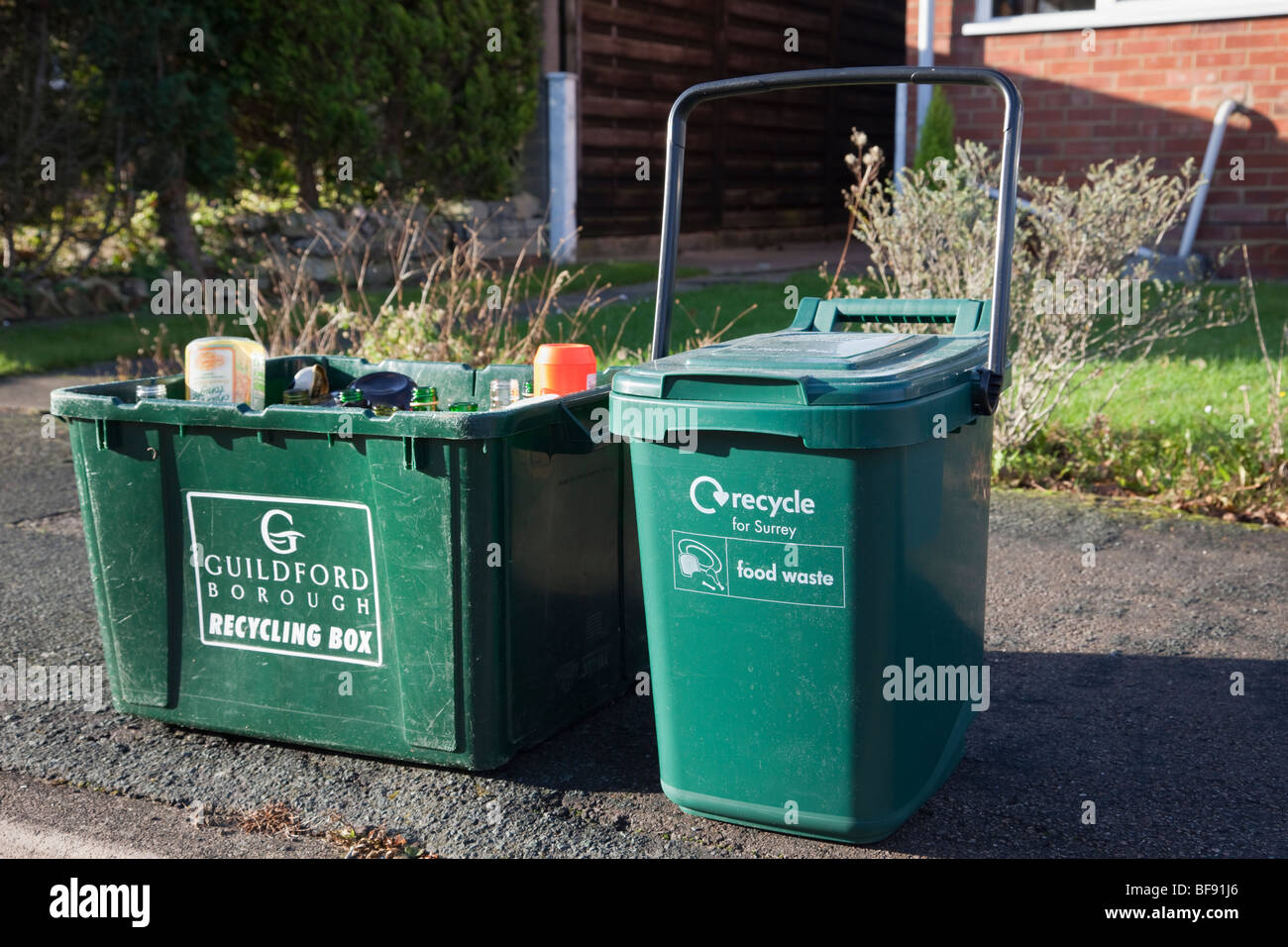 Grüne curbside Recyclingkartons für Glas- und Speiseresten warten auf Sammlung auf einer Kandare außerhalb eines Hauses. Surrey England Großbritannien Großbritannien Stockfoto