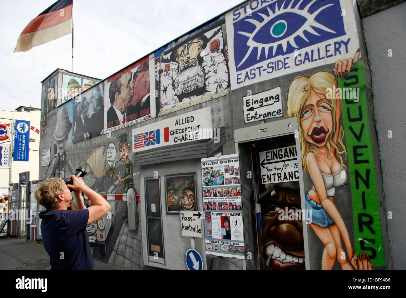 Ein Tourist fotografiert ein Souvenirgeschäft Berliner Mauer an der East Side Gallery, einem 1,3 km langen Abschnitt der Berliner Mauer Stockfoto