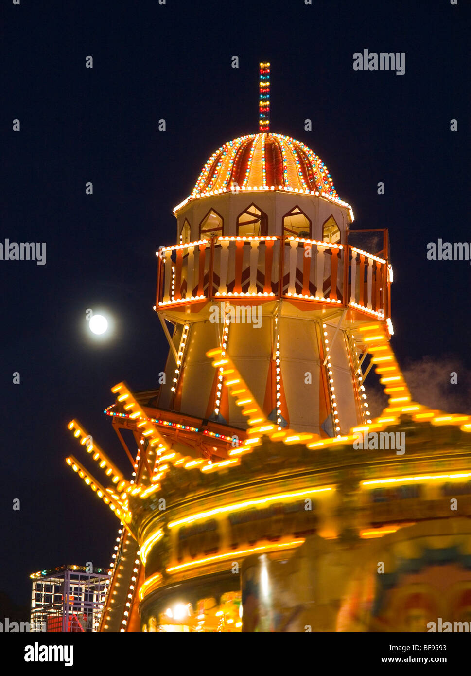 Helter Skelter und Karussell gegen den Mond bei Goose Fair in Nottingham, Nottinghamshire, England UK Stockfoto