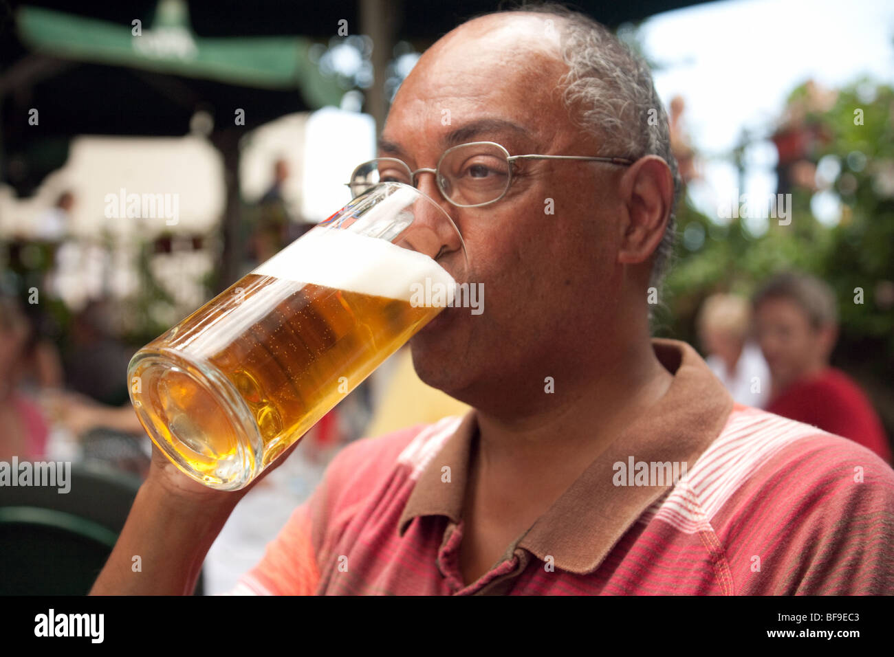 Mann mittleren Alters indische trinken einen Pint lager Stockfoto