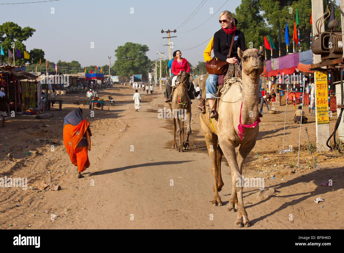 Kamelreiten auf der Camel Fair in Pushkar in Rajasthan Indien Touristen Stockfoto