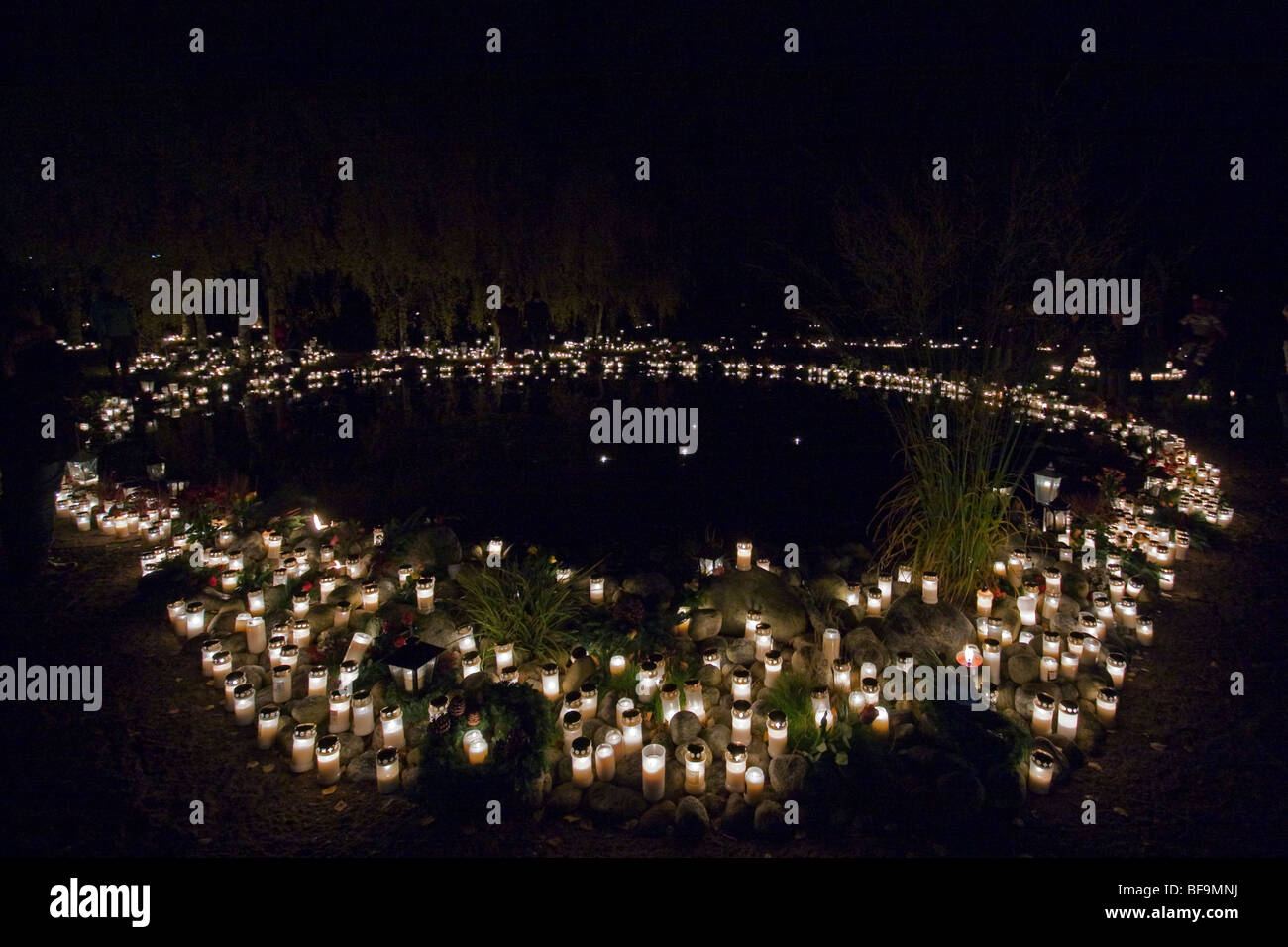 Memorial Grove an einem Teich in einem schwedischen Friedhof. Menschen zünden Kerzen für ihre Vorfahren. Stockfoto
