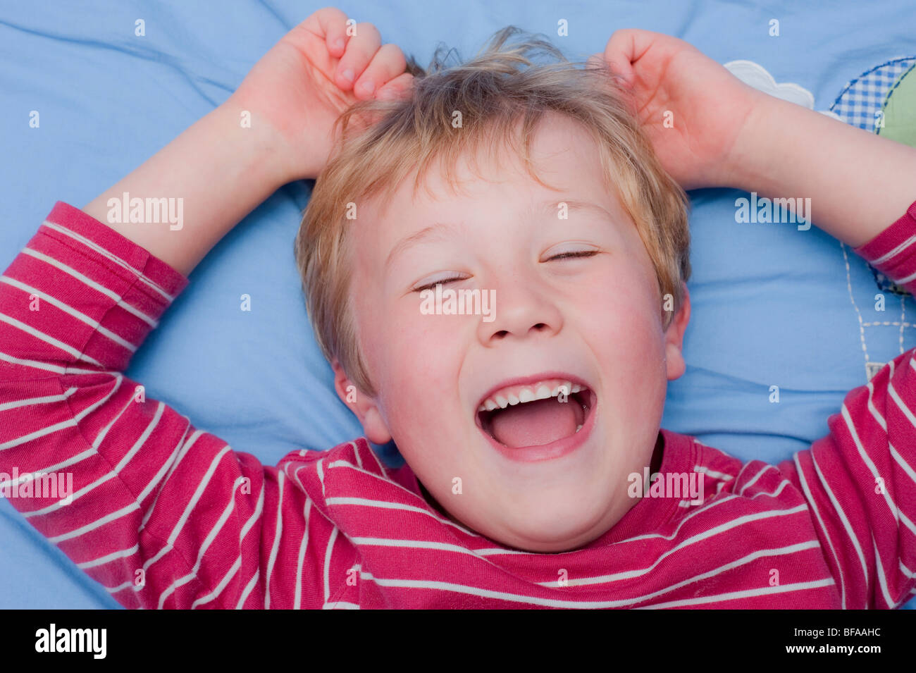 Ein Model Release Bild eines sechsjährigen Jungen Lachen drinnen im Vereinigten Königreich Stockfoto