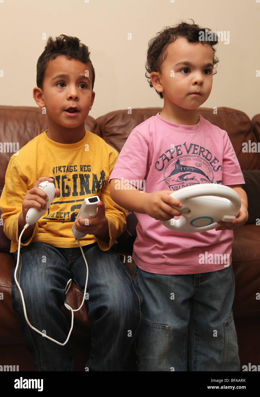 2 Brüder im Alter von 3 und 6 spielen Nintendo Wii Stockfoto