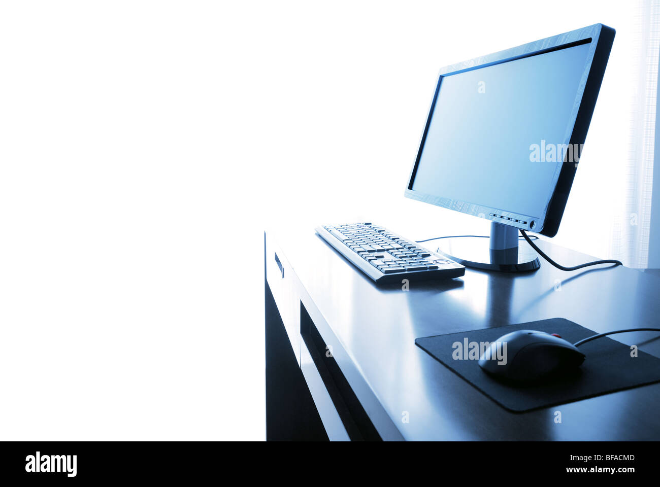 Büroalltag, Computer mit Schreibtisch isoliert auf die weiss - blau getönt. Stockfoto