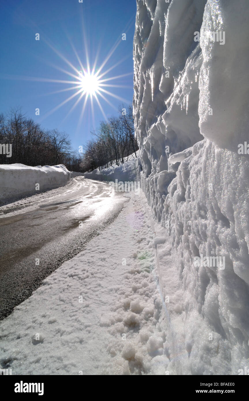 Bergstraße mit angetriebenen Schneeverwehungen Wand nach Schneepflug Aktion Stockfoto