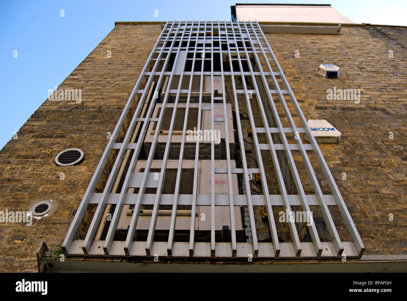 Eisengitter auf einer Außenwand Schutz eine Reihe von Klimaanlage Maschine Ventilatoren in Richmond nach Themse, Surrey, england Stockfoto